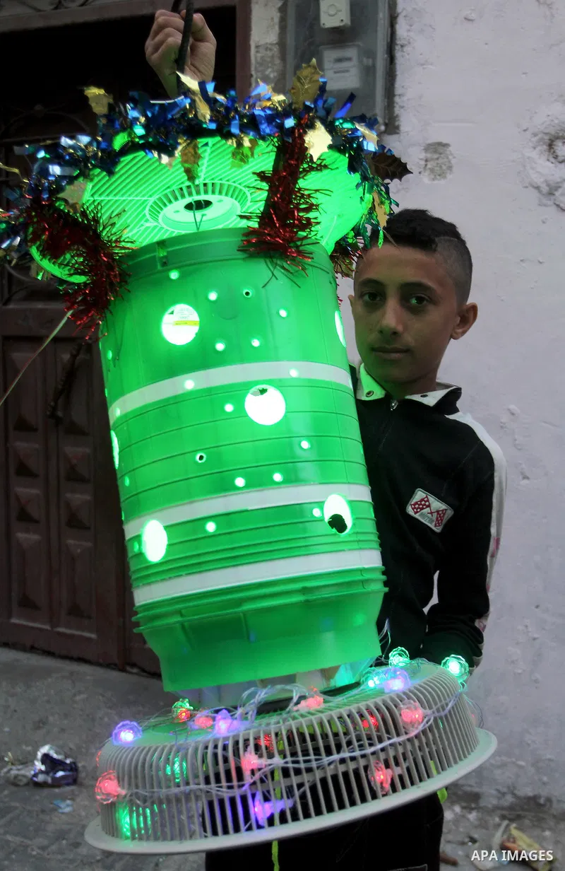 A Palestinian boy holds a traditional lanterns known in Arabic as "Fanous" that are used during the holy month of Ramadan in the Rafah refugee camp in southern Gaza Strip on May 30, 2016. Photo by Abed Rahim Khatib