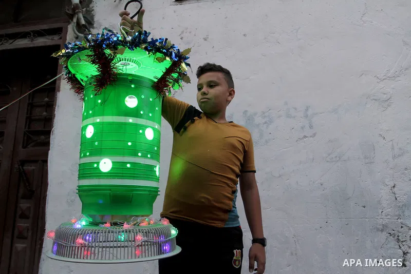 A Palestinian boy holds a traditional lanterns known in Arabic as "Fanous" that are used during the holy month of Ramadan in the Rafah refugee camp in southern Gaza Strip on May 30, 2016. Photo by Abed Rahim Khatib