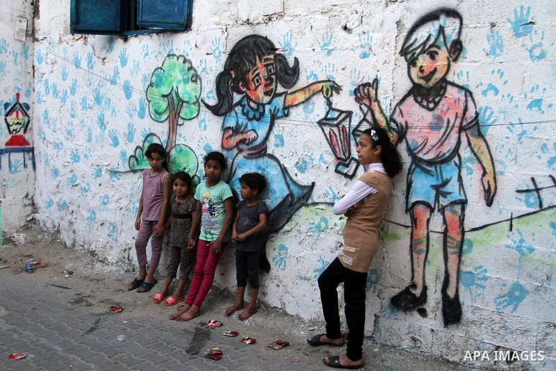 Palestinian children stand outside their house during hang up decorations before the holy month of Ramadan in the Rafah refugee camp in southern Gaza Strip on May 30, 2016. Photo by Abed Rahim Khatib