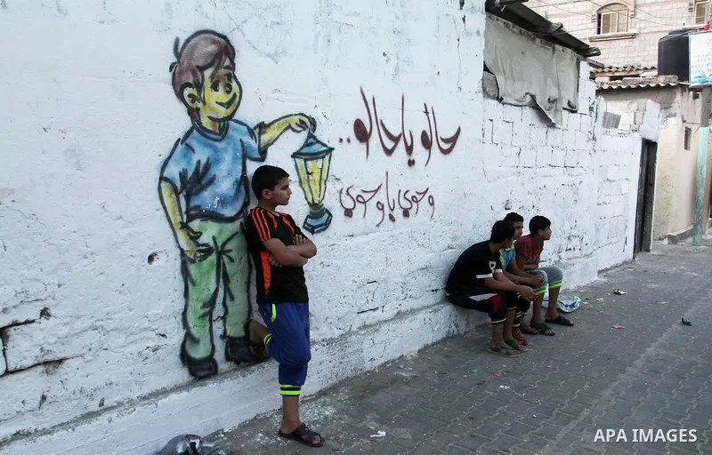 Palestinian children stand outside their house during hang up decorations before the holy month of Ramadan in the Rafah refugee camp in southern Gaza Strip on May 30, 2016. Photo by Abed Rahim Khatib