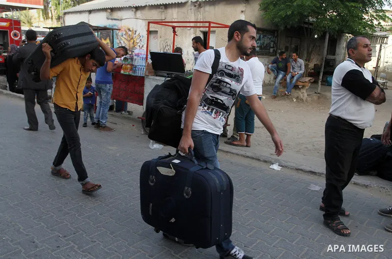 Palestinians wait for travel permits to cross into Egypt through the Rafah border crossing after it was opened for four days by Egyptian authorities, in the southern Gaza Strip June 1, 2016. Photo by Abed Rahim Khatib