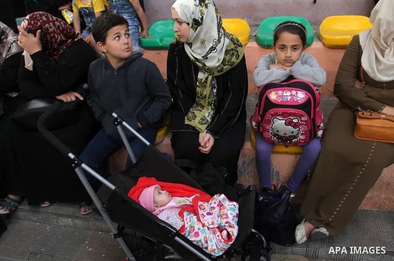Palestinians wait for travel permits to cross into Egypt through the Rafah border crossing after it was opened for four days by Egyptian authorities, in the southern Gaza Strip June 1, 2016. Photo by Abed Rahim Khatib