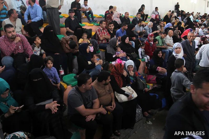 Palestinians wait for travel permits to cross into Egypt through the Rafah border crossing after it was opened for four days by Egyptian authorities, in the southern Gaza Strip June 1, 2016. Photo by Abed Rahim Khatib