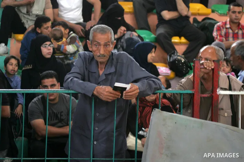 Palestinians wait for travel permits to cross into Egypt through the Rafah border crossing after it was opened for four days by Egyptian authorities, in the southern Gaza Strip June 1, 2016. Photo by Abed Rahim Khatib
