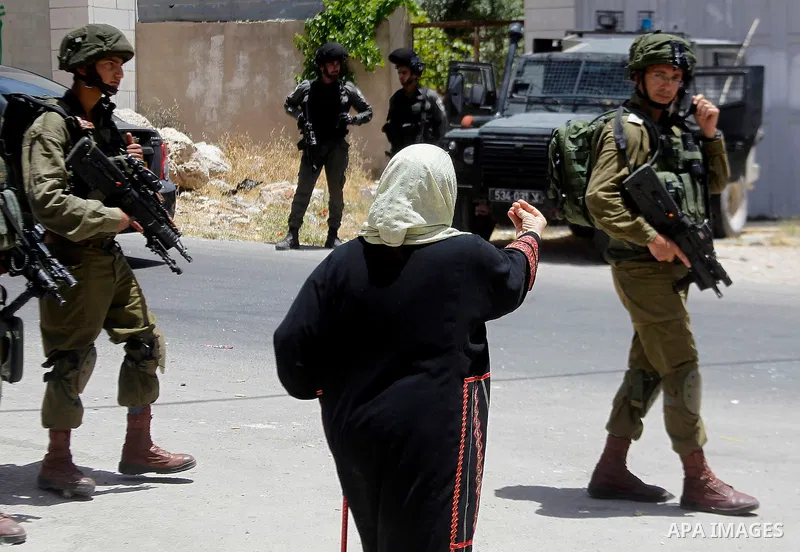 A Palestinian woman argues with Israeli troops during a Palestinian man was detain by Israeli troops who the Israeli military said that he was throw a molotov cocktail, in the West Bank city of Hebron 01 June 2016. Photo...