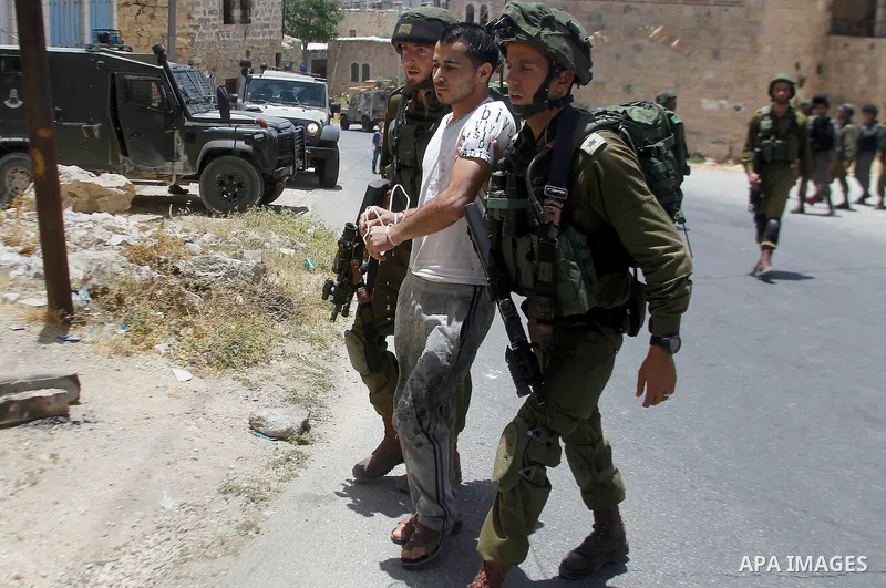Israeli troops detain a Palestinian man, who the Israeli military said he was throw a molotov cocktail towards Israeli troops, in the West Bank city of Hebron 01 June 2016. Photo by Wisam Hashlamoun