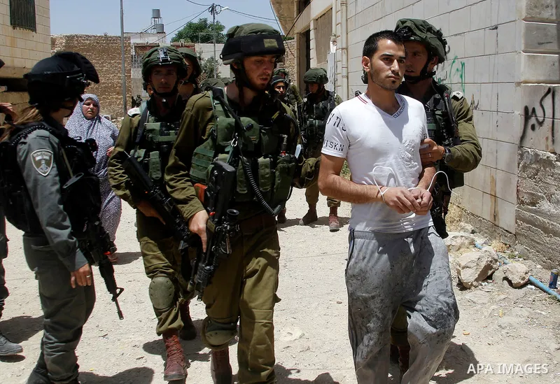 Israeli troops detain a Palestinian man, who the Israeli military said he was throw a molotov cocktail towards Israeli troops, in the West Bank city of Hebron 01 June 2016. Photo by Wisam Hashlamoun