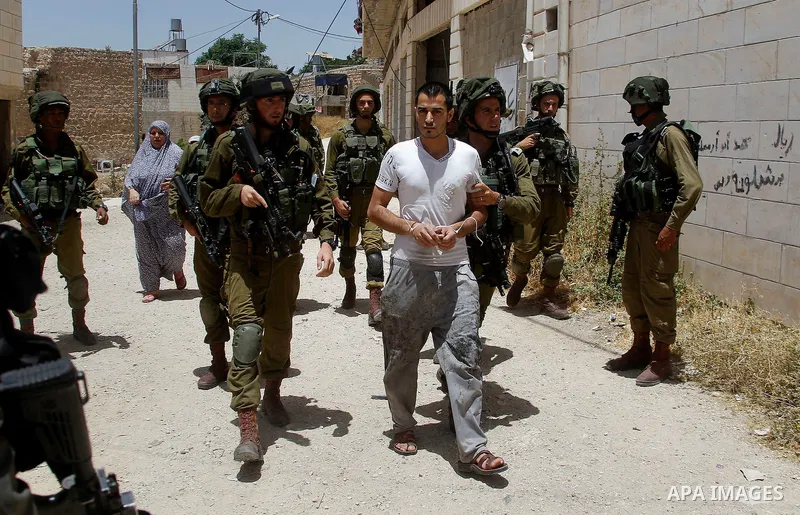 Israeli troops detain a Palestinian man, who the Israeli military said he was throw a molotov cocktail towards Israeli troops, in the West Bank city of Hebron 01 June 2016. Photo by Wisam Hashlamoun