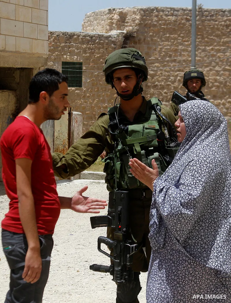 A Palestinian woman argues with Israeli troops during a Palestinian man was detain by Israeli troops who the Israeli military said that he was throw a molotov cocktail, in the West Bank city of Hebron 01 June 2016. Photo...