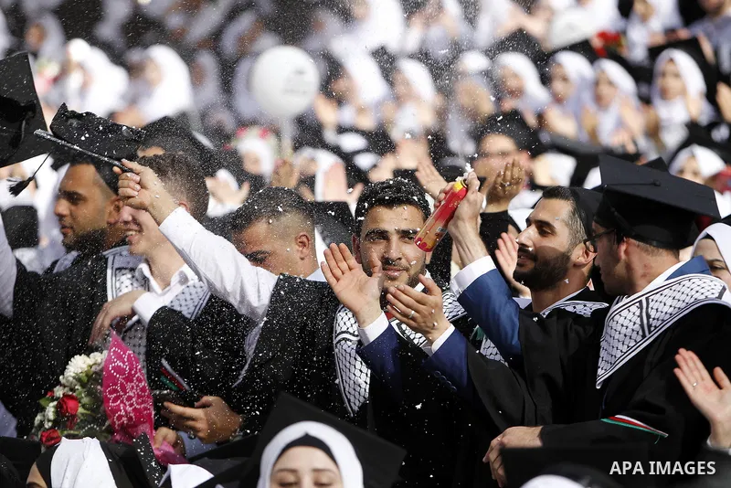 Palestinian students attend their graduation ceremony at the end of the academic year on June 01, 2016 at Hebron University in the West Bank city of Hebron. Photo by Wisam Hashlamoun