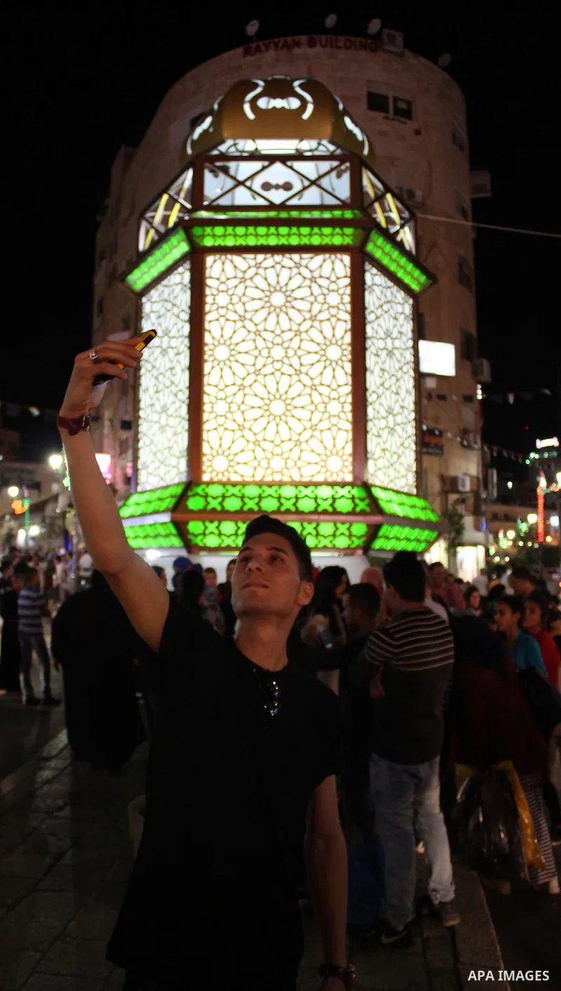 Palestinians celebrate during the ceremony of lighting Ramadan a traditional lantern known in Arabic as "Fanous" in the West bank city of Ramallah, on June 02, 2016. Photo by Hamza Shalash