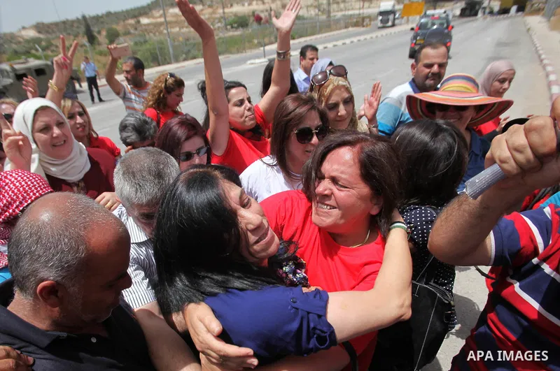 Prominent Palestinian lawmaker Khalida Jarrar hugs a supporter at the Jubara checkpoint near the northern West Bank city of Tulkarem, following her release from an Israeli jail on June 3, 2016, after serving a 15-month s...
