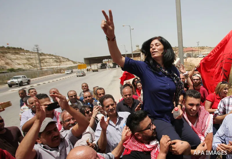 Prominent Palestinian lawmaker Khalida Jarrar is lifted up by supporters at the Jubara checkpoint near the northern West Bank city of Tulkarem, following her release from an Israeli jail on June 3, 2016, after serving a...
