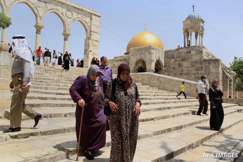 Palestinian Muslim worshipers walk in front of the Dome of the Rock mosque following Friday prayers at al-Aqsa mosque,Islam's third holiest site, in Jerusalem's Old city on June 03, 2016 on the last Friday before the Isl...