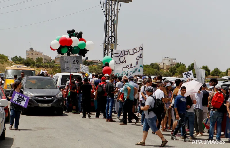 Palestinian and Israeli activists take part in a demonstration in support of peace near the West Bank city of Bethlehem June 3, 2016. Photo by Wisam Hashlamoun