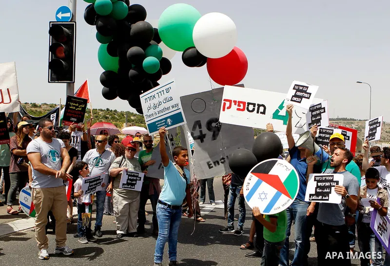 Palestinian and Israeli activists take part in a demonstration in support of peace near the West Bank city of Bethlehem June 3, 2016. Photo by Wisam Hashlamoun