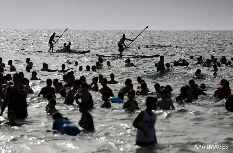 Palestininas swim in the Mediterranean sea on the coast of Gaza city, on June 03, 2016 on the last Friday before the Islamic holy month of Ramadan. Photo by Mohammed Asad