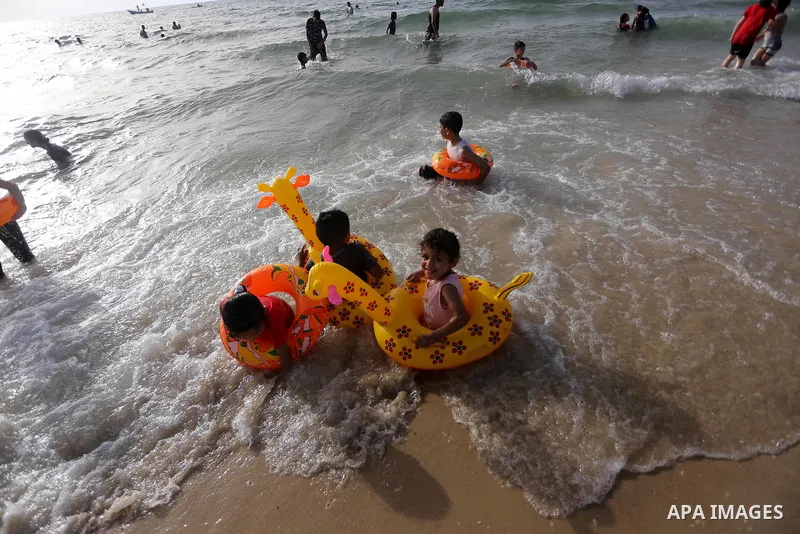 Palestininas swim in the Mediterranean sea on the coast of Gaza city, on June 03, 2016 on the last Friday before the Islamic holy month of Ramadan. Photo by Mohammed Asad