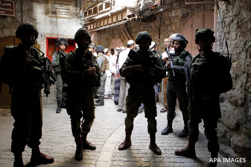 Israeli troops guard Israeli settlers during their weekly tour through the Old City of West Bank city of Hebron, 04 June 2016. Every Saturday a tour through Hebron's Old City, which is usually off limits for Israeli sett...