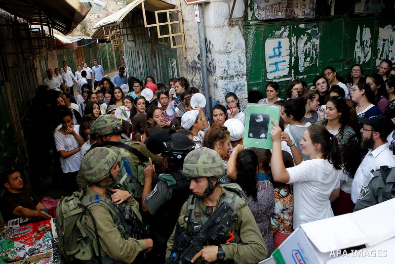 Israeli troops guard Israeli settlers during their weekly tour through the Old City of West Bank city of Hebron, 04 June 2016. Every Saturday a tour through Hebron's Old City, which is usually off limits for Israeli sett...
