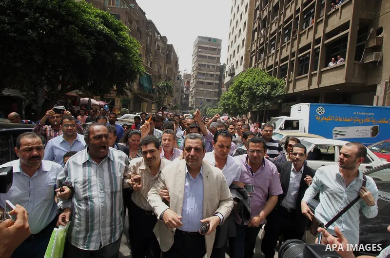 Yahia Kalash, the head of the journalists' union, is surrounded by cameramen as he arrives at Cairo south court in Cairo, Egypt, Saturday, June 4, 2016. The head of Egypt's journalists union and two of its board members...