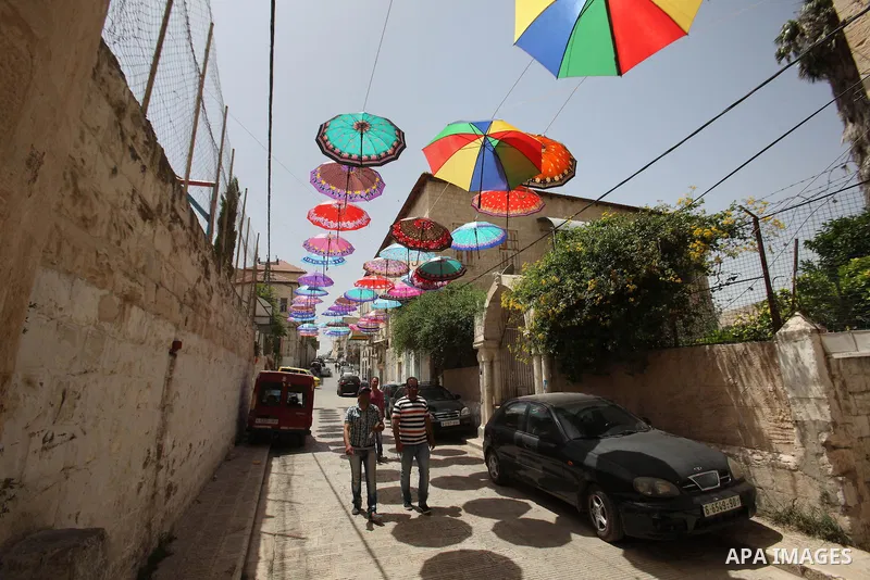 Palestinians walk under show umbrellas used to decorate a street in the Old City of the West Bank town of Nablus, on June 5, 2016 as the faithful prepare to start fasting month of Ramadan. More than 1.5 billion Muslims a...