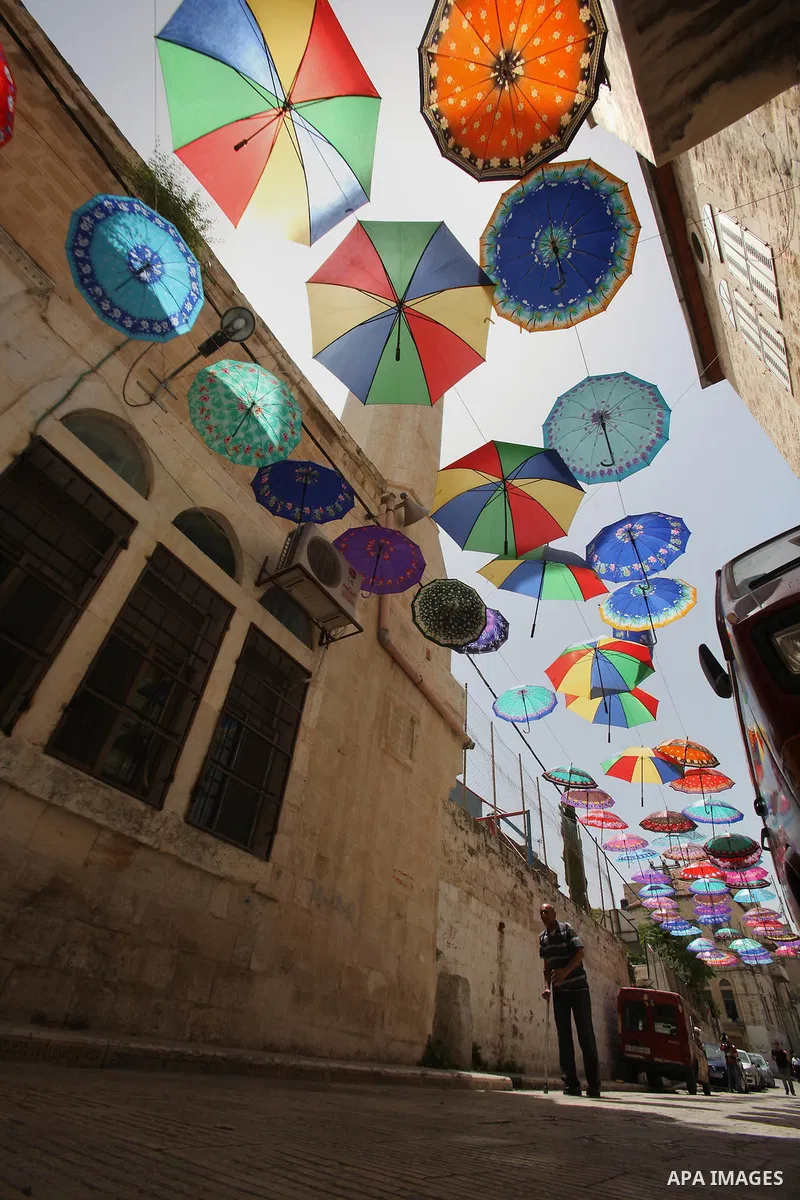 Palestinians walk under show umbrellas used to decorate a street in the Old City of the West Bank town of Nablus, on June 5, 2016 as the faithful prepare to start fasting month of Ramadan. More than 1.5 billion Muslims a...