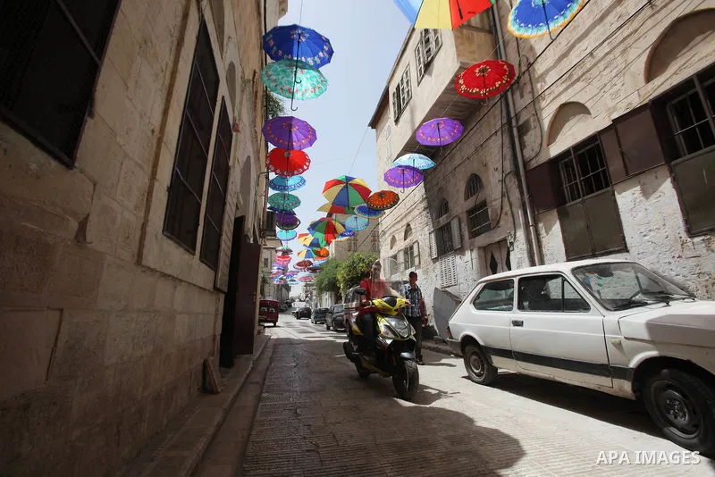 Palestinians walk under show umbrellas used to decorate a street in the Old City of the West Bank town of Nablus, on June 5, 2016 as the faithful prepare to start fasting month of Ramadan. More than 1.5 billion Muslims a...