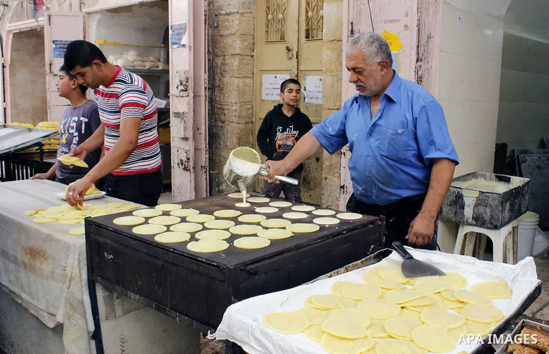A Palestinian man prepares traditional pancakes known as ''Qatayef'' at market in the Old City of the West Bank town of Hebron, on June 5, 2016 as the faithful prepare to start fasting month of Ramadan. More than 1.5 bil...