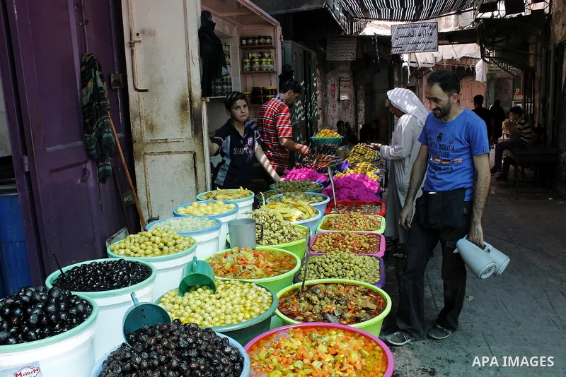 A Palestinian vendor sells pickles at market in the Old City of the West Bank town of Hebron, on June 5, 2016 as the faithful prepare to start fasting month of Ramadan. More than 1.5 billion Muslims around the world will...