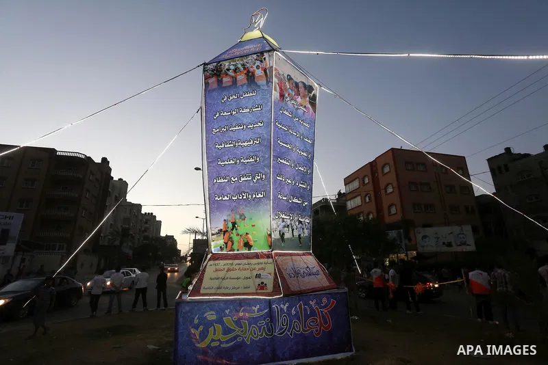 Palestinian children take part in a street celebration during the ceremony of lighting Ramadan a traditional lantern known in Arabic as "Fanous", in the beginning of the Muslim holy month of Ramadan in Gaza city, on June...
