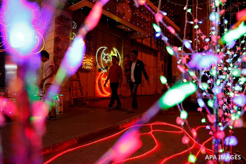 Palestinians walk at street under hang up decorations ahead of the beginning of the Muslim holy month of Ramadan in the West bank city of Hebron, on June 05, 2016. More than 1.5 billion Muslims around the world will star...