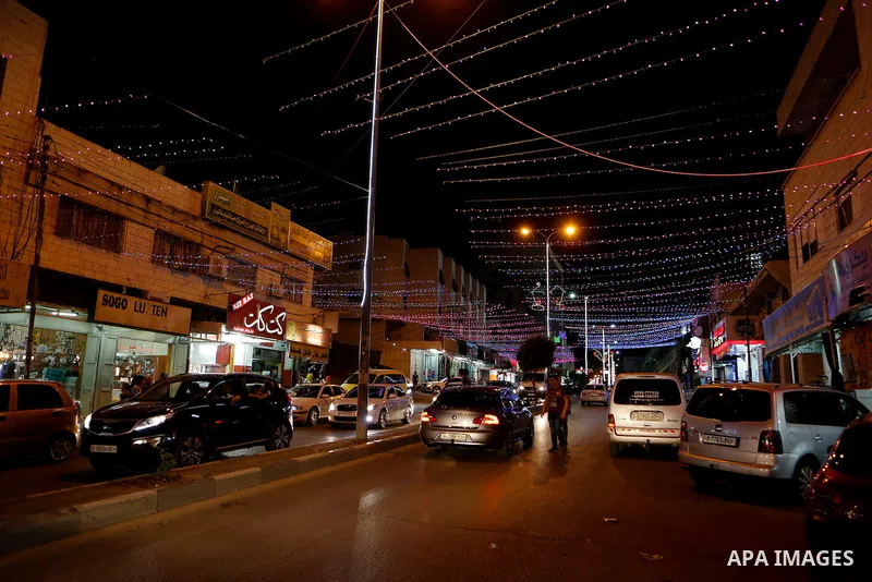 Palestinians walk at street under hang up decorations ahead of the beginning of the Muslim holy month of Ramadan in the West bank city of Hebron, on June 05, 2016. More than 1.5 billion Muslims around the world will star...