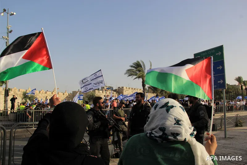 Palestinian demonstrators are separated by Israeli policemen and barriers from Israelis taking part in an annual march marking Israel's 1967 seizure of the Palestinian-dominated eastern half of Jerusalem, outside Damascu...