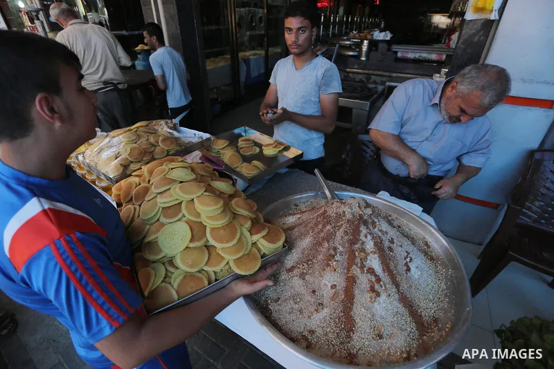 A Palestinian man prepares traditional pancakes known as ''Qatayef at a market on the first day of the Ramadan, in Gaza city, on June 6, 2016 as the faithful prepare to start fasting. More than 1.5 billion Muslims around...