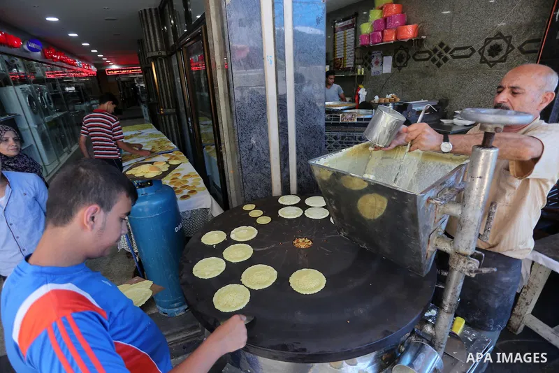 A Palestinian man prepares traditional pancakes known as ''Qatayef at a market on the first day of the Ramadan, in Gaza city, on June 6, 2016 as the faithful prepare to start fasting. More than 1.5 billion Muslims around...