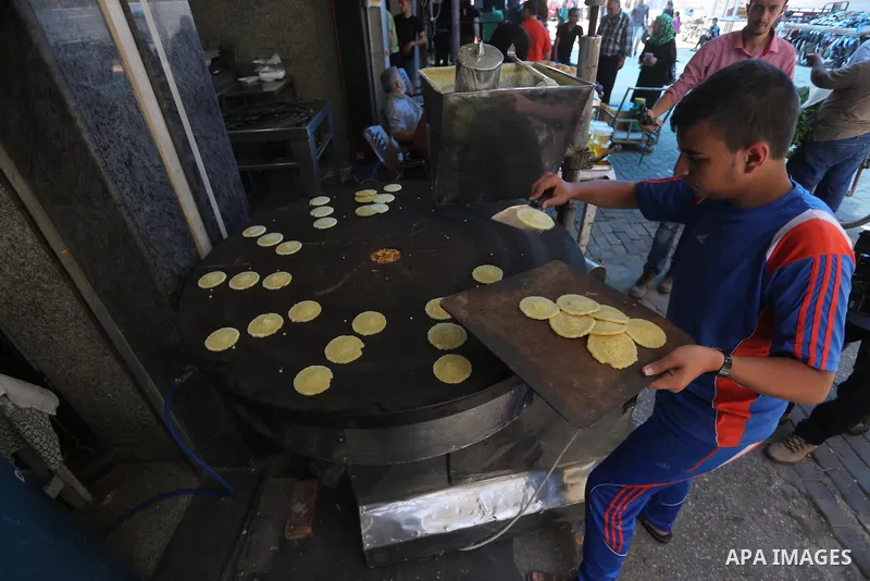 A Palestinian man prepares traditional pancakes known as ''Qatayef at a market on the first day of the Ramadan, in Gaza city, on June 6, 2016 as the faithful prepare to start fasting. More than 1.5 billion Muslims around...
