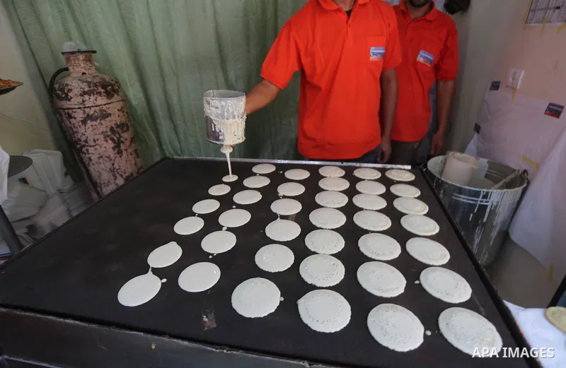 A Palestinian man prepares traditional pancakes known as ''Qatayef at a market on the first day of the Ramadan, in Gaza city, on June 6, 2016 as the faithful prepare to start fasting. More than 1.5 billion Muslims around...