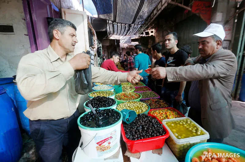 A Palestinian man sells pickles at a market on the first day of the Ramadan in the Old City of the West Bank town of Hebron, on June 6, 2016 as the faithful prepare to start fasting month of Ramadan. More than 1.5 billio...