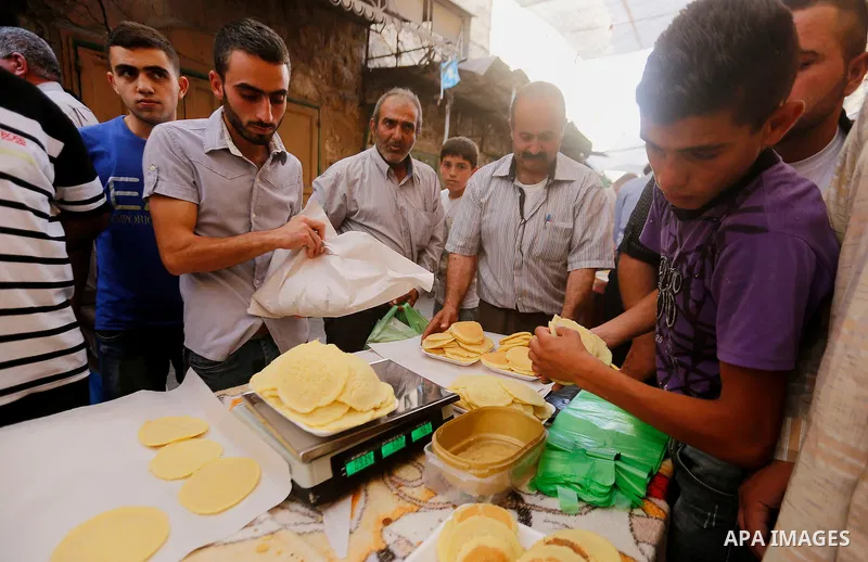 A Palestinian man prepares traditional pancakes known as ''Qatayef'' at market on the first day of the Ramadan in the Old City of the West Bank town of Hebron, on June 6, 2016 as the faithful prepare to start fasting mon...