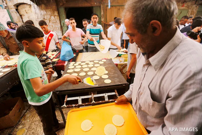 A Palestinian man prepares traditional pancakes known as ''Qatayef'' at market on the first day of the Ramadan in the Old City of the West Bank town of Hebron, on June 6, 2016 as the faithful prepare to start fasting mon...