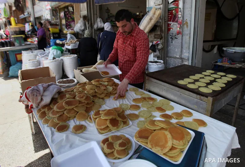 A Palestinian man prepares traditional pancakes known as ''Qatayef'' on the holy month of Ramadan at market in the Old City of the West Bank town of Nablus, on June 7, 2016. Ramadan is sacred to Muslims because it is dur...