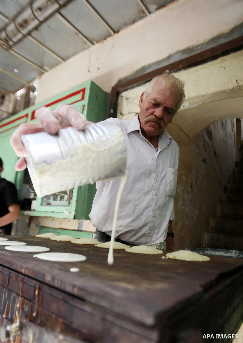 A Palestinian man prepares traditional pancakes known as ''Qatayef'' on the holy month of Ramadan at market in the Old City of the West Bank town of Nablus, on June 7, 2016. Ramadan is sacred to Muslims because it is dur...
