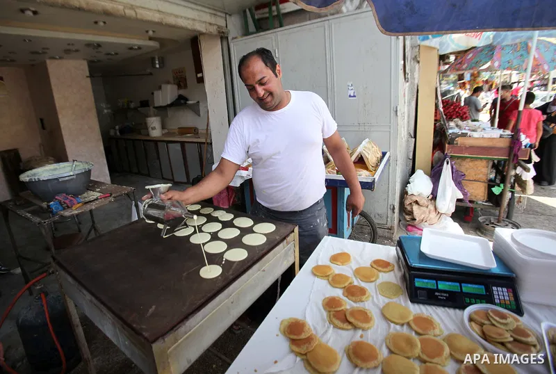 A Palestinian man prepares traditional pancakes known as ''Qatayef'' on the holy month of Ramadan at market in the Old City of the West Bank town of Nablus, on June 7, 2016. Ramadan is sacred to Muslims because it is dur...