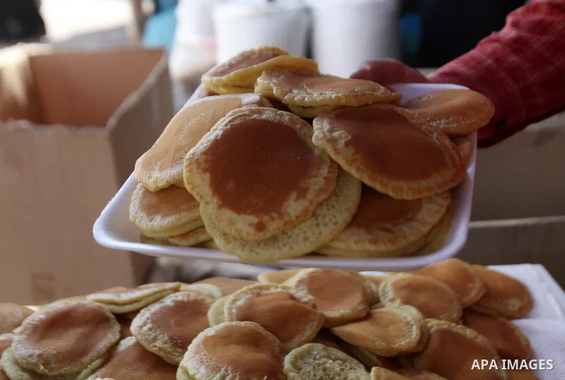 A Palestinian man prepares traditional pancakes known as ''Qatayef'' on the holy month of Ramadan at market in the Old City of the West Bank town of Nablus, on June 7, 2016. Ramadan is sacred to Muslims because it is dur...