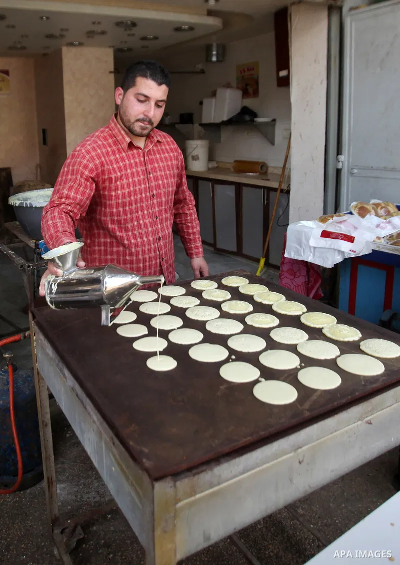 A Palestinian man prepares traditional pancakes known as ''Qatayef'' on the holy month of Ramadan at market in the Old City of the West Bank town of Nablus, on June 7, 2016. Ramadan is sacred to Muslims because it is dur...