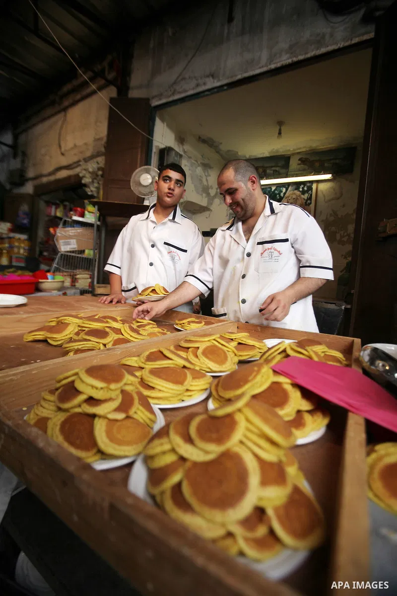 A Palestinian man prepares traditional pancakes known as ''Qatayef'' on the holy month of Ramadan at market in the Old City of the West Bank town of Nablus, on June 7, 2016. Ramadan is sacred to Muslims because it is dur...