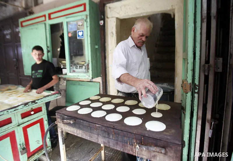 A Palestinian man prepares traditional pancakes known as ''Qatayef'' on the holy month of Ramadan at market in the Old City of the West Bank town of Nablus, on June 7, 2016. Ramadan is sacred to Muslims because it is dur...