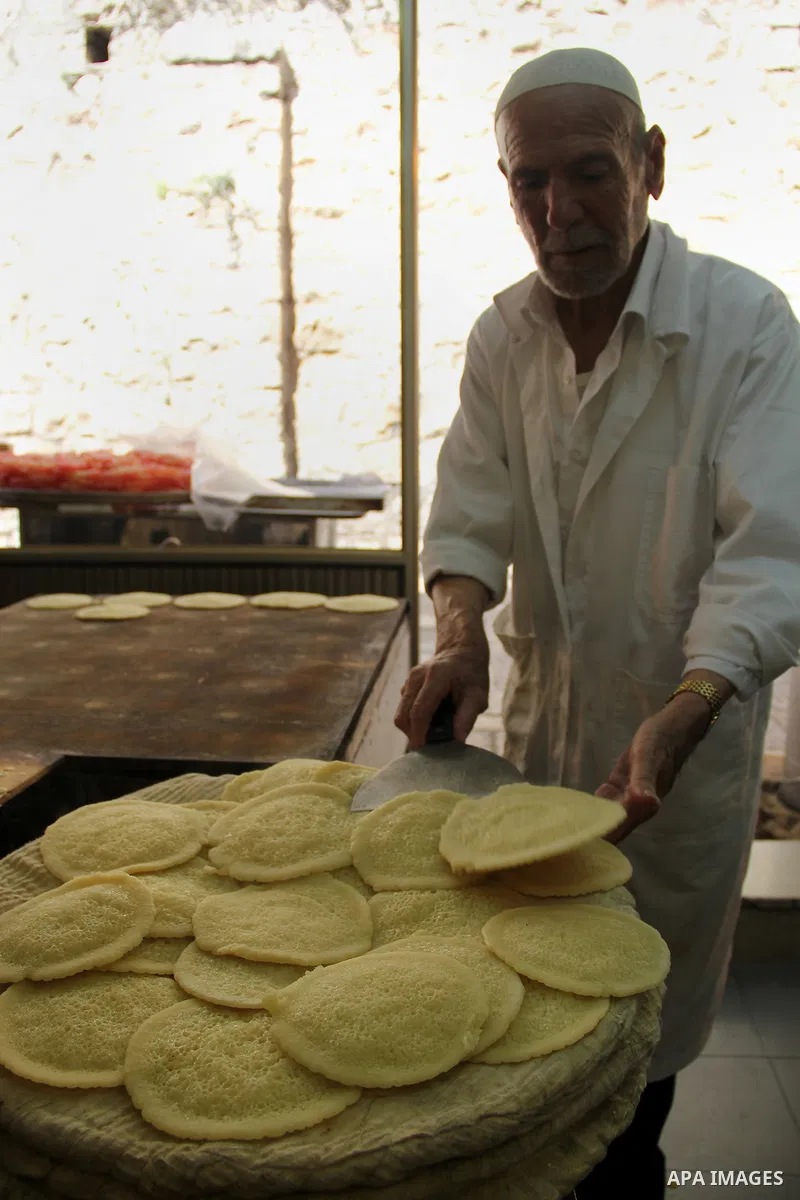 A Palestinian man prepares traditional pancakes known as ''Qatayef'' on the holy month of Ramadan at a market in Jerusalem's old city on June 7, 2016. Ramadan is sacred to Muslims because it is during that month that tra...
