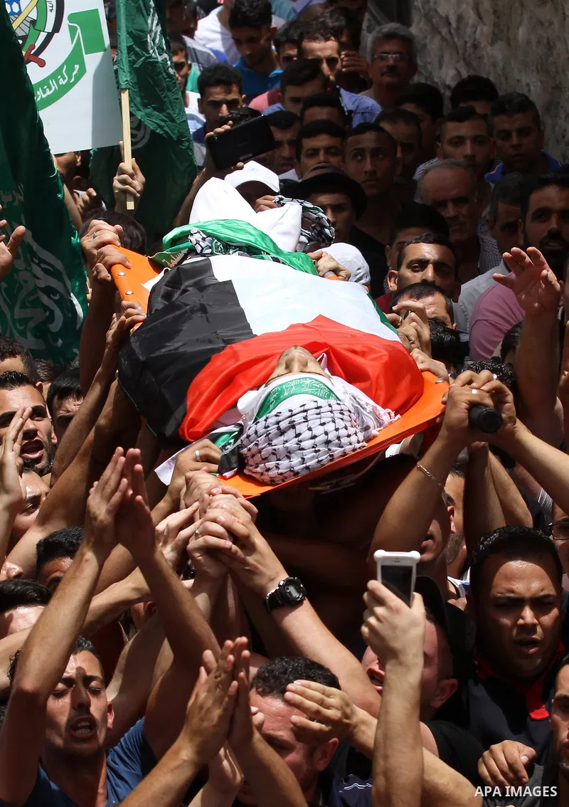 Mourners carry the body of Palestinian Jamal Dwikat, who died from wounds he sustained after he was shot during clashes with the Israeli army on Friday, during his funeral in the West Bank village of Balata Albalad near...